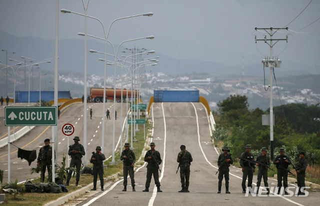 (AP Photo/뉴시스) 베네수엘라와 콜롬비아를 잇는 티엔디타스 국제다리에 8일(현지시간) 베네수엘라 군인들이 보초를 서고 있다. 군인들 뒤로는 해외 원조를 차단하기 위해 설치된 연료탱커와 카고 트레일러, 임시 울타리가 보인다.