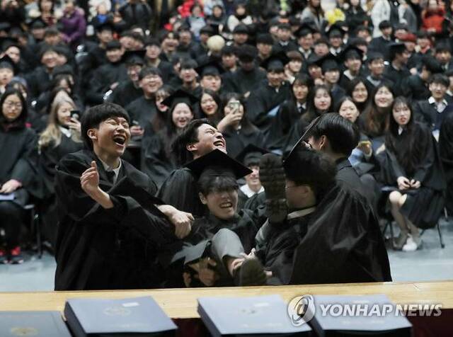 12일 오전 서울 용산구 선린인터넷고등학교에서 열린 제111회 졸업식에서 한 졸업생이 친구들을 향해 뛰어들고 있다. (출처: 연합뉴스)