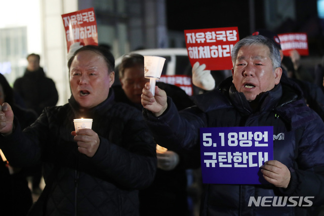 【서울=뉴시스】 14일 오후 서울 영등포구 자유한국당사 앞에서 한국진보연대가 주최한 '5·18 망언 비호하는 자유한국당 해체 촛불문화제'에서 한 시민이 '자유한국당은 해체하라'는 문구가 적힌 피켓을 들고 있다.