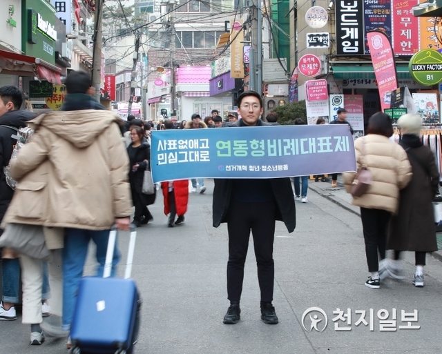 [천지일보=안현준 기자] 선거개혁 청년·청소년행동 소속 한 회원이 18일 오후 서울 마포구 홍대 앞 걷고 싶은 거리에서 만18세 선거권 하향 및 연동형비례제 도입 촉구 하며 피켓을 들고 있다. ⓒ천지일보 2019.2.18