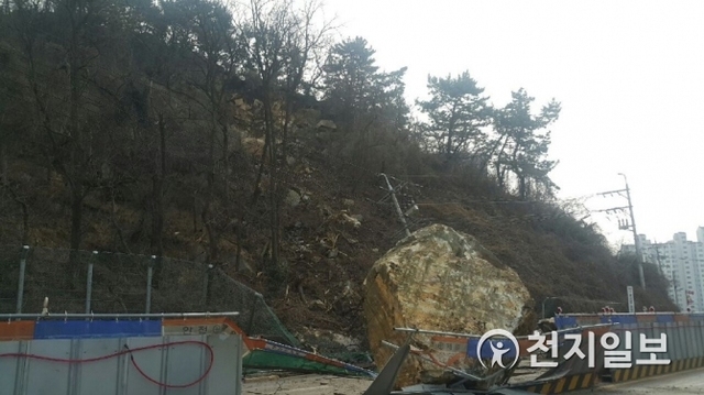 부산 사하구 지하철 공사 현장과 인접한 승학산 산비탈 일부가 무너진 데 이어 큰 바위가 떨어져 도로를 덮치는 사고가 발생했다. (제공: 부산경찰청) ⓒ천지일보 2019.2.22