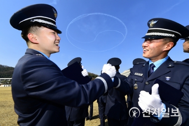 8일 공군사관학교 성무연병장에서 거행된 공사 제67기 졸업 및 임관식에서 졸업생들이 블랙이글스의 축하 비행이 이뤄진 가운데 서로 졸업을 축하하고 있다. (제공: 국방부) 2019.3.8