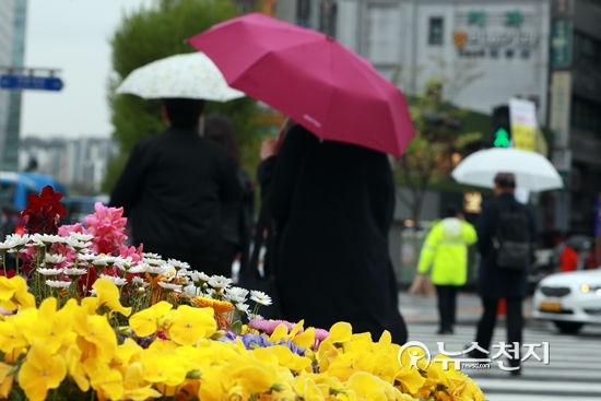 봄비가 내리는 가운데 지난 17일 시민이 서울 종로구 광화문 근처 횡단보도를 건너고 있다. ⓒ천지일보