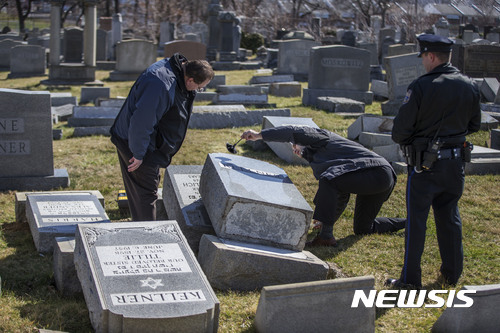 미국 필라델피아 마운트 카멜 공동묘지에서 26일(현지시간) 경찰들이 훼손된 유대인 묘석에서 지문을 채취하고 있다. (출처: 뉴시스)