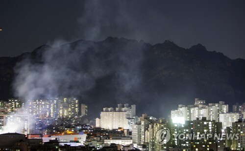 (서울=연합뉴스) 13일 서울 은평구 모델하우스 화재의 불씨가 옮겨붙은 북한산 일대에서 야간 화재 진화작업이 진행되고 있다.