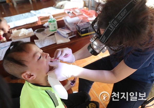치과의사가 아이의 치아에 불소를 도포하고 있다. (제공: 신천지자원봉사단 강서지부) ⓒ천지일보 2019.3.12