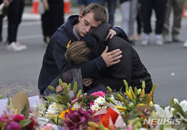 16일(현지시간) 뉴질랜드 크라이스트처치의 마스지드 알 누르 모스크 인근 임시 추모소에서 시민들이 총기난사로 숨진 희생자들에 대한 조의를 표하고 있다. (출처: 뉴시스)