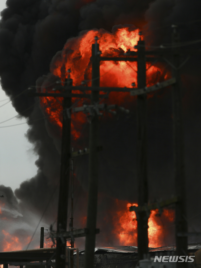 【디어파크=AP/뉴시스】18일(현지시간) 미 텍사스주 휴스턴 남동부 디어 파크 소재 인터콘티넨탈 석유화학 터미널에서 불이 나 시뻘건 불길과 검은 연기가 치솟고 있다. 소방당국은 다행히 인명 피해는 보고된 바 없으며 화재 진압에 앞으로 이틀은 더 걸릴 것 같다고 밝혔다.