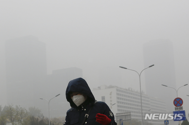 중국 최대 정치 행사인 양회가 끝나자마자 또다시 베이징에 스모그가 덮쳤다.사진은 작년 11월 중국 베이징 도심에서 마스크를 착용하고 걸어가는 한 시민의 모습. (출처: 뉴시스)