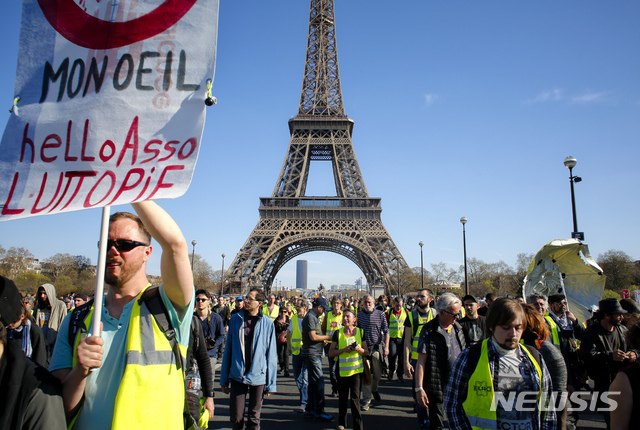 【파리=AP/뉴시스】프랑스 에펠탑 인근에서 30일(현지시간) 노란조끼 시위대가 행진하고 있다.