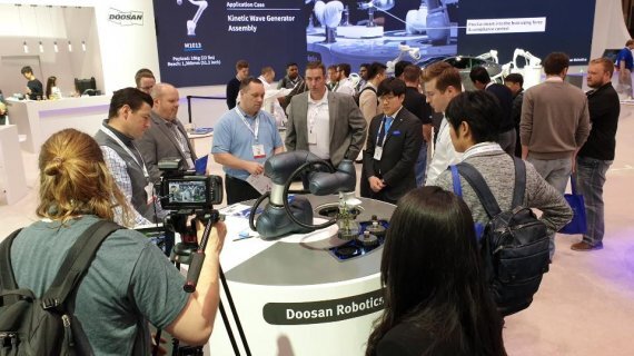 두산로보틱스가 8~11일까지 미국 시카고에서 열리는 ‘오토메이트 2019’에 참가해 두산 협동로봇을 미국 시장에 처음으로 선보였다. 관람객들이 두산로보틱스의 협동로봇의 시연을 유심히 지켜보고 있다. (제공: 두산로보틱스)