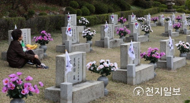 [천지일보=남승우 기자] 4.19혁명 59주년인 19일 오후 서울 강북구 국립4.19 민주묘지에서 한 유가족이 희생자의 묘에 앉아 생각에 잠겨있다. ⓒ천지일보 2019.4.19