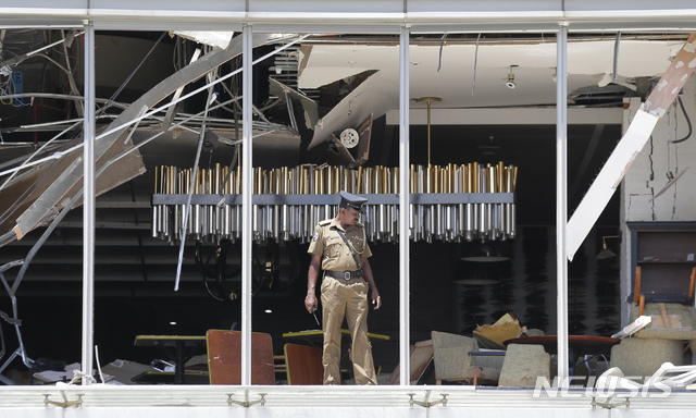 부활절인 21일(현지시간) 스리랑카 수도 콜롬보의 교회와 호텔 등에서 폭탄 테러가 발생해 한 경관이 폭발이 일어난 샹그리라 호텔 현장을 살피고 있다. (출처: 뉴시스)