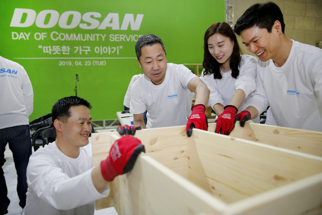 박정원 두산그룹 회장(가운데)이 임직원들과 함께 인근 지역 가정에 전달할 가구를 제작하고 있다. (제공: 두산)