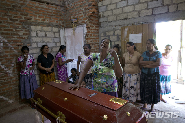스리랑카 네곰보에서 22일(현지시간) 전날 벌어진 자폭테러 희생자 가족이 12세 어린이의 시신이 담긴 관을 손으로 짚으며 오열하고 있다. (출처: 뉴시스)