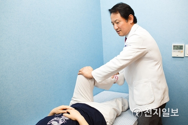더본병원 김준한 대표원장이 환자의 무릎을 움직이며 관절의 건강상태를 파악하고 있다. (제공: 더본병원) ⓒ천지일보 2019.4.26