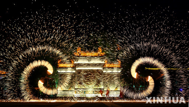 2일(현지시간) 중국 산둥성 자오장의 고대 도시 타이얼장에서 노동절 축제가 열려 공연자들이 쇳물 불꽃 공연을 펼치고 있다. (출처: 뉴시스)