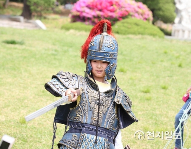 서울 광진구 아차산성과 관련된 복식체험에 참여한 한 아이가 장군의 갑옷과 투구를 착용하고 검을 휘둘고 있다. ⓒ천지일보 2019.5.4