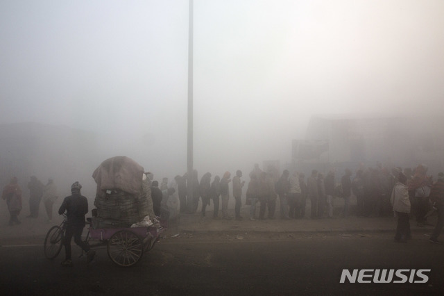 인도 뉴델리에서 새해 첫날 1일 스모그로 뿌연 아침에 노숙자들이 무료 급식을 위해 줄 서 있다. (출처: 뉴시스)