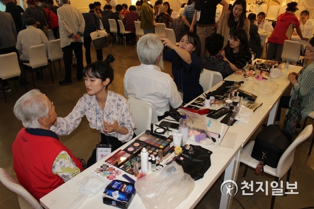 성신여자대학교가 22일 개최한 성북구 독거어르신 초청행사의 메이크업부스에서 성신체인지봉사단 학생들의 메이크업 시연이 진행되고 있다. (제공: 성신여자대학교) ⓒ천지일보