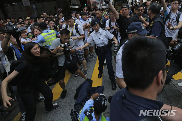 【홍콩=AP/뉴시스】홍콩에서 9일 한 경찰이 시민들과 대치하던 중 쓰러져 있다. 이날 홍콩에서는 범죄인 인도법에 반대하는 대규모 시위가 벌어졌다.
