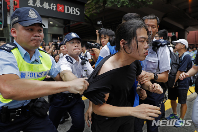 9일(현지시간) 홍콩의 한 시민이 '범죄인 인도 법안' 반대 행진 중 경찰에 끌려가고 있다. 자정이 넘어가며 홍콩섬 곳곳에서 시위대와 경찰의 무력 충돌이 벌어지고 있다고 SCMP는 전했다(출처: 뉴시스)