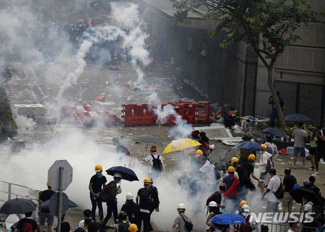 【홍콩=AP/뉴시스】홍콩 경찰들이 12일 입법원 근처 도로에서 범죄인 인도법 반대 시위대를 향해 최루탄을 쏘고 있다.