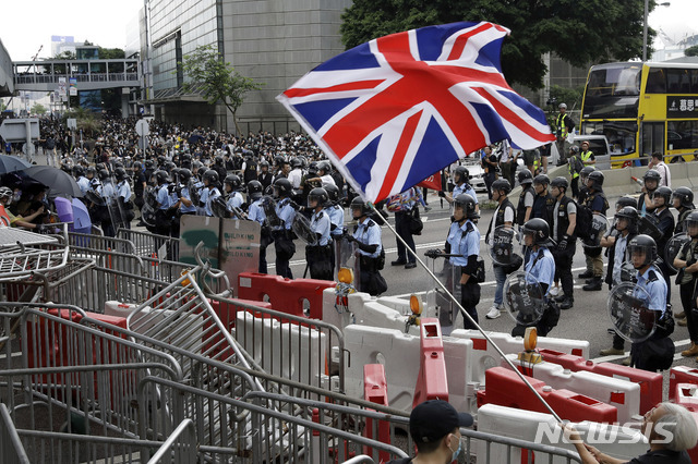 홍콩 의회 격인 입법회 앞에서 12일 범죄인 인도법 반대 시위에 참석한 한 남성이 옛 식민 종주국인 영국 국기를 흔들고 있다(출처: 뉴시스)