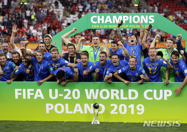 15일(현지시간) 폴란드 우치의 우치 스타디움에서 막을 내린 2019 국제축구연맹(FIFA) U20 월드컵 결승에서 대한민국을 3-1로 꺾고 우승을 차지한 우크라이나 선수들이 우승컵을 앞에 두고 기념촬영을 하고 있다. (출처: 뉴시스)