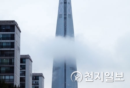 소나기가 내린 10일 오후 서울 송파구 롯데월드타워가 비구름에 갇혀있다. ⓒ천지일보