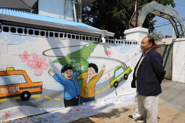 The Wonju branch of Shincheonji Volunteer Group held a wall painting event for about a week from 12th of May in which they expressed their earnest desire for peaceful unification. A citizen is looking at a mural wishing for peaceful unification.(Photo by:Shincheonji Volunteer Group)