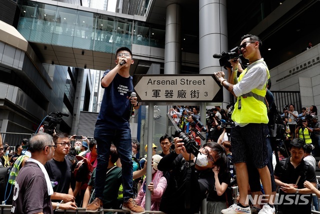 지난 2014년 홍콩 우산시위를 주도했던 조슈아 웡이 21일 범죄인 인도법 반대 시위대에게 경찰본부를 에워싸줄 것을 요청하고 있다(출처: 뉴시스)