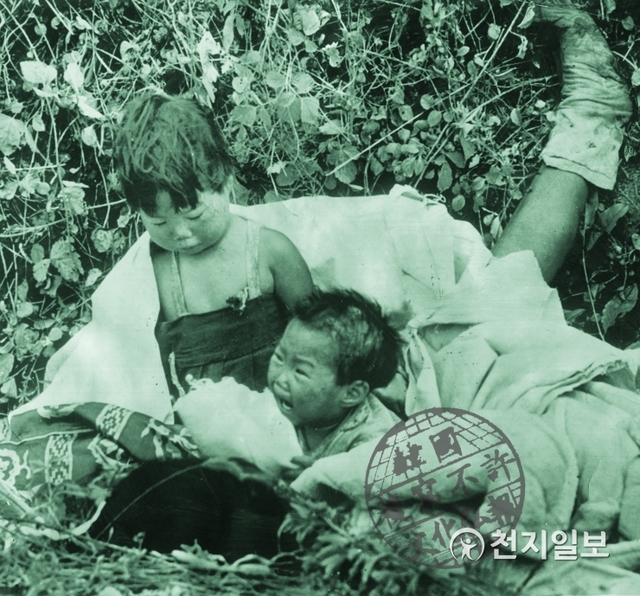 엄마 잃은 피란민 어린이들(1950년 10월 21, 26일 2차례 AP보도): KOREA WAR REFUGEES CHILDREN. 한국전쟁의 최악의 비극을 담은 이 사진은 북한의 수도인 평양에서 배수로를 따라 난 길 위에 언니는 어머니의 몸 옆에 웅크리고 있고 아이는 흐느끼며 울고 있는 모습을 담고 있다. (제공: 정성길 명예박물관장) ⓒ천지일보 2019.6.25