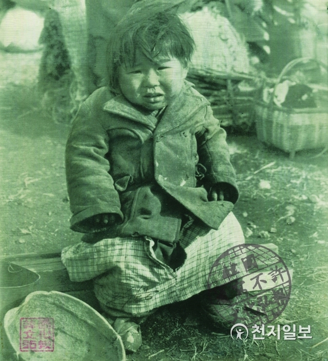 추위와 굶주림에 울고 있는 피난민 아이(1951년 1월 16일). HELP ME, PLEASE!- How much can a little girl take? cold, hungry and in rags, a tiny Korean refugee weeps as she sits on a dock at Pusan. 제발 좀 도와주세요! 이 어린 소녀는 얼마나 이동 하였을까? 누더기 옷을 입고 추위와 굶주림에 부산의 부두위에 앉아서 울고 있는 한 한국인 피난민 아이. 끊임없는 피난이 끝나기만 기다리고 있다. (제공: 정성길 명예박물관장) ⓒ천지일보 2019.6.25