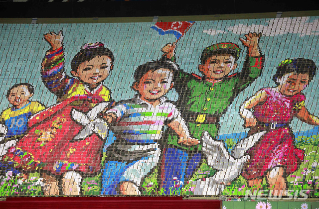 (평양=AP/뉴시스) 25일 평양 능라도의 5월1일 경기장에서 '인민의 땅'이라는 주제로 집단체조 행사가 열려 북한의 어린이들을 상징하는 카드 섹션이 펼쳐지고 있다. 집단체조는 북한이 사회주의 종합 예술이라고 자랑하는 대표 여행 상품으로 1970년대 시작했으며 북한을 방문하는 외국인 관광객은 이를 의무적으로 관람해야 하는 것으로 알려지고 있다. 