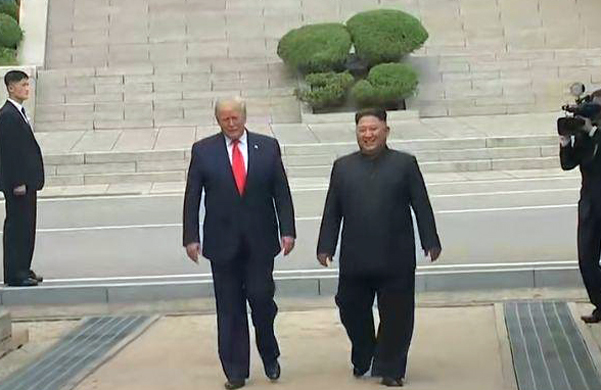 30일 오후 판문점 공동경비구역(JSA)에서 김정은 북한 국무위원장과 도널드 트럼프 미국 대통령이 함께 남북 군사분계선(MDL)을 넘나들며 분단 66년 만에 역사적인 모습을 기록하고 있다. (출처: YTN 생중계 캡처) 2019.6.30