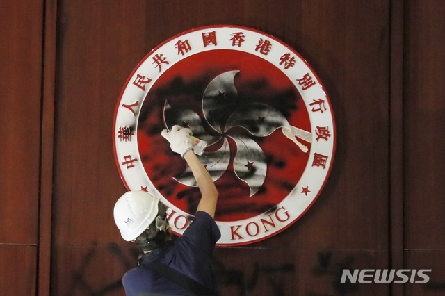 홍콩에서 1일 시위대가 입법회를 점거한 가운데 한 남성이 홍콩 엠블럼에 검은색 스프레이를 뿌리고 있다. (출처: 뉴시스)