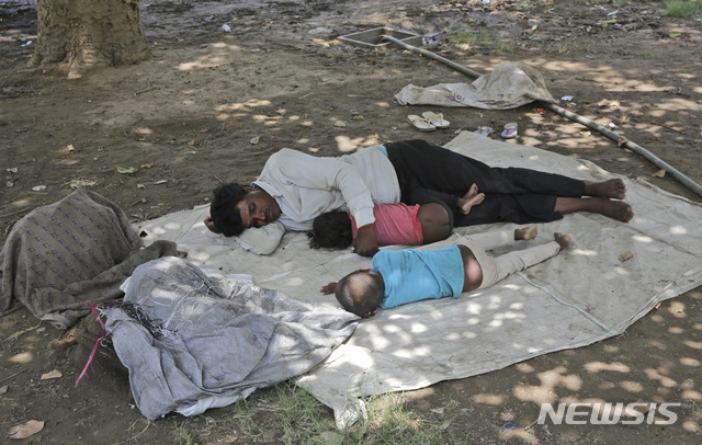 6월 10일(현지시간) 인도 뉴델리 공원에서 한 가족이 나무 그늘에서 폭염을 피해 낮잠을 자고 있다.  (출처: 뉴시스)