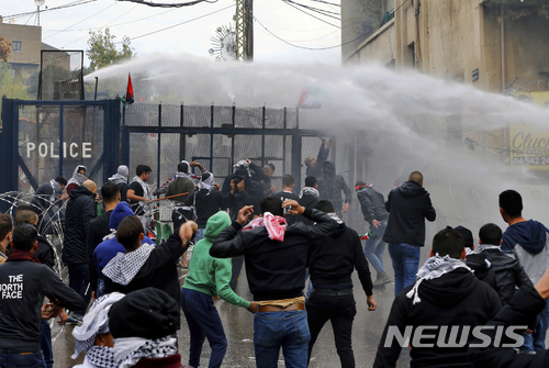10일(현지시간) 레바논 수도의 미국 대사관 앞에서 트럼프 대통령의 예루살렘 '이스라엘 수도' 인정에 항의하는 시위대가 레바논 경찰의 물대포을 뚫고 대사관 진입을 시도하고 있다. (출처: 뉴시스)