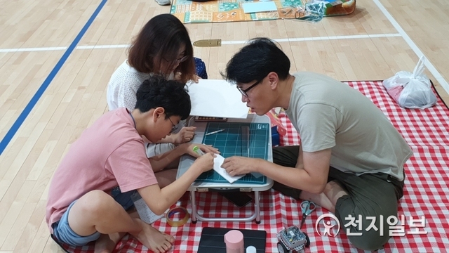 지난 12일 인천삼산초등학교 강당에서 열린 로봇체험 캠프에 한 가족이 참여하고 있다. (제공: 인천시교육청) ⓒ천지일보 2019.7.16