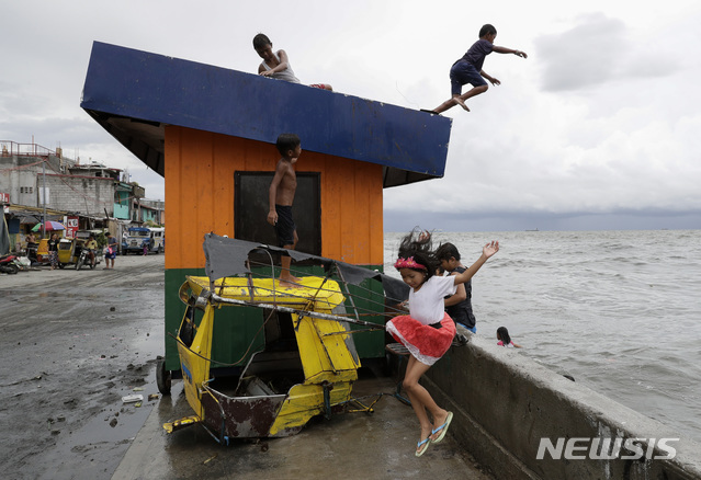 17일(현지시간) 집중 호우의 영향으로 높은 파도에도 불구하고 필리핀 마닐라만에서 남자아이들이 물속으로 뛰어들며 놀고 있다. (출처: 뉴시스)