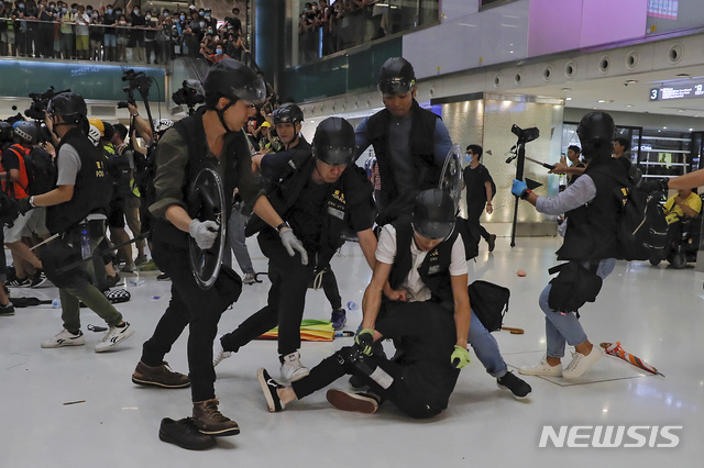 14일 홍콩 샤틴지역의 한 쇼핑몰에서 홍콩 경찰들이 한 시위자를 체포하고 있다(출처: 뉴시스)