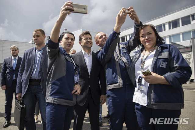 젤렌스키(가운데) 우크라이나 대통령이 10일(현지시간) 체르노빌에서 열린 새로운 안전확보장치 가동식에 참석해 현장을 둘러보고 관계자들과 기념촬영을 하고 있다.(출처: 뉴시스)