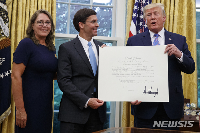 도널드 트럼프(오른쪽) 미국 대통령이 23일(현지시간) 백악관 집무실에서 마크 에스퍼(가운데) 신임 국방장관에게 임명장을 전달하고 기념 촬영을 하고 있다. 왼쪽은 마크 에스퍼의 부인 레아 에스퍼(출처: 뉴시스)