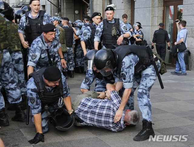 27일 러시아 모스크바에서 공정선거를 촉구하는 시위가 열린 가운데, 경찰이 시위에 참석한 남성 1명을 체포하고 있다. (출처: 뉴시스)