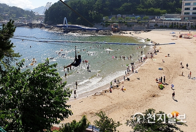 [천지일보 진주=최혜인 기자] 지난달 31일 사천시 남일대해수욕장에서 한 피서객이 해수욕장을 관통하는 200m 길이의 에코라인(집라인)을 타고 바다를 건너고 있다. ⓒ천지일보 2019.8.1