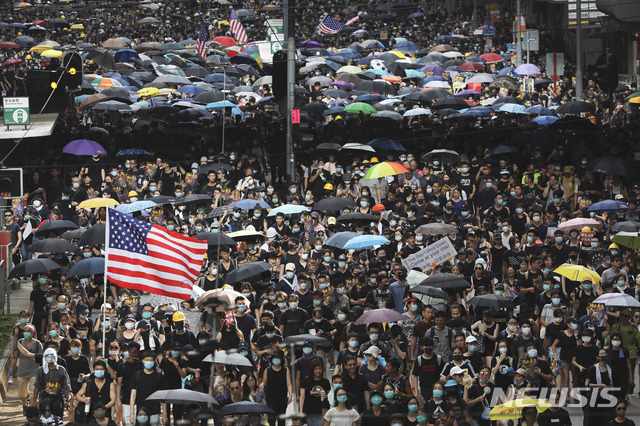 홍콩에서 반중국 친민주주의 주말 행진시위가 8번째로 펼쳐진 28일 검은 셔츠를 입고 우산을 든 시위대 사이에서 커다란 미국 성조기가 펄럭이고 있다. (출처: 뉴시스)