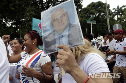 리카르도 마르티넬리 전 파나마 대통령의 지지자들이 지난 달 11일 수도 파나마시티 대법원 앞에서 그의 사진을 들고 석방을 요구하고 있다(출처: 뉴시스)