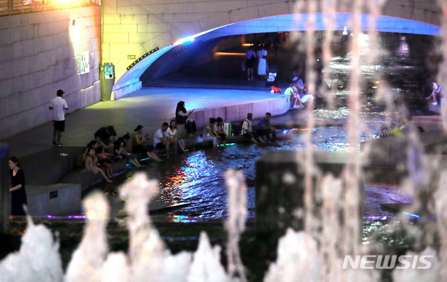 한 낮 찜통더위 속에 열대야가 이어진 13일 오후 서울 종로구 청계천을 찾은 시민들이 물에 발을 담그며 더위를 식히고 있다. (출처: 뉴시스)