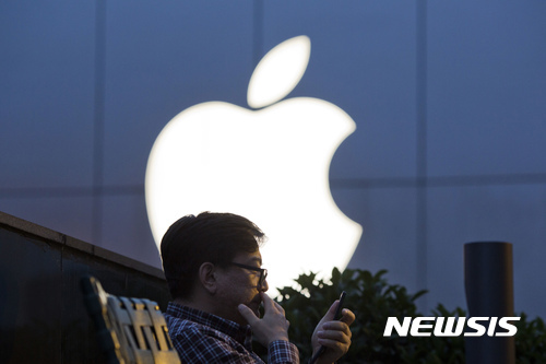 중국 베이징에 있는 애플 매장 앞에서 한 남성이 스마트폰을 보고 있다. (출처: 뉴시스)